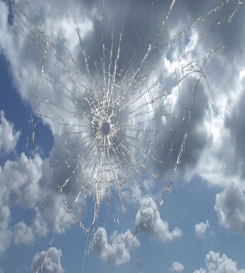 Shattered window with sky in the background