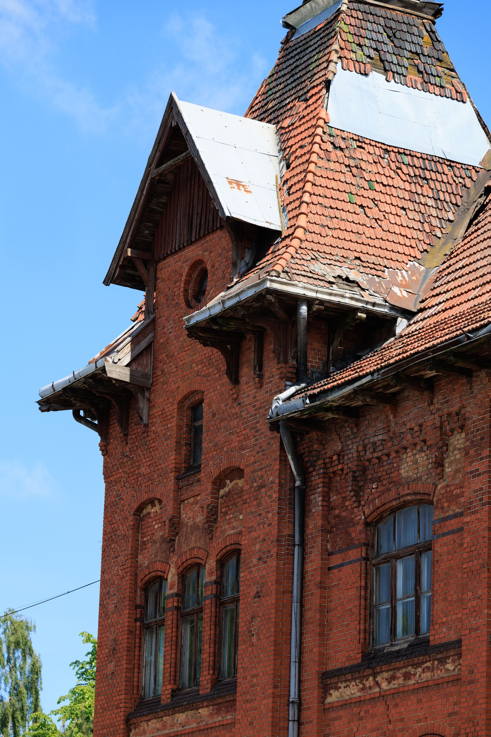 Detailed image of a historic red brick building with a damaged roof in Gvardeysk, Russia.