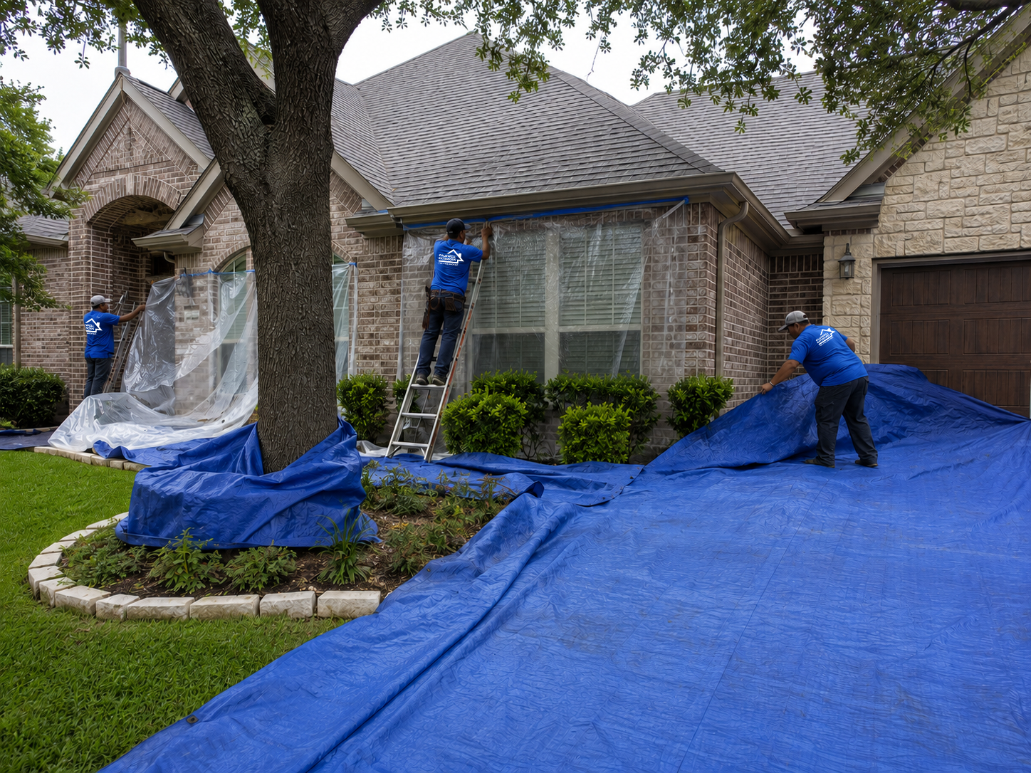 Caldwell Exteriors roofing crew covering windows, landscaping, and exterior surfaces with protective tarps before a residential roof replacement in Garland, Texas.
